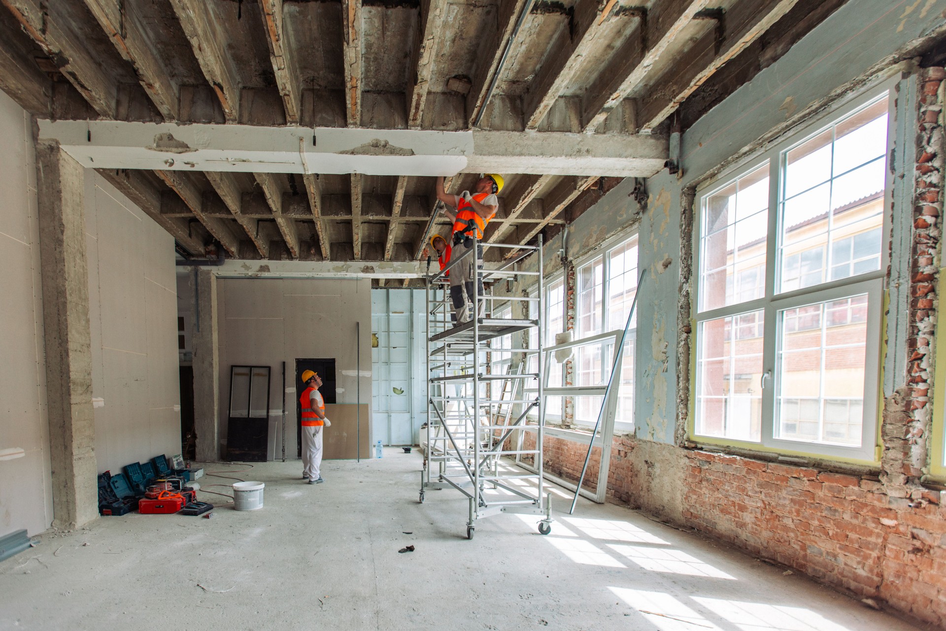 Construction workers on scaffold renovating an old building